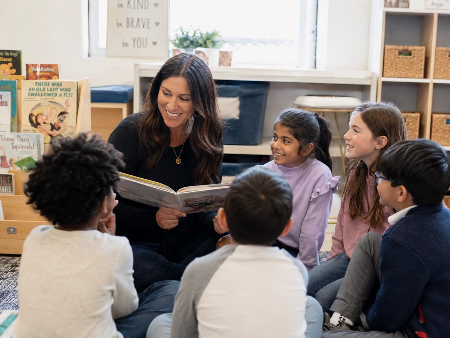 A classroom teacher reading with elementary students